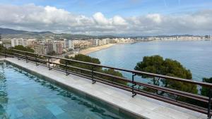 a swimming pool next to a body of water at Eden Mar Calonge Girona in Calonge