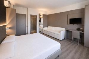 a bedroom with a large white bed and a couch at LVG Hotel Collection - Principe in Modena