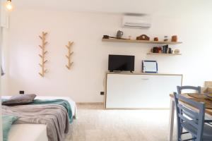 a white room with a bed and a tv on a wall at Casa Malika a Otranto in Otranto