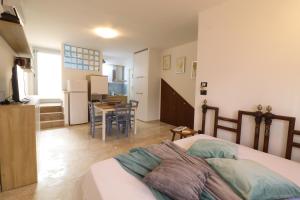 a bedroom with a bed and a kitchen with a table at Casa Malika a Otranto in Otranto