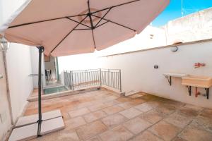 a large umbrella on the balcony of a house at Casa Malika a Otranto in Otranto