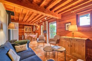 a living room with a blue couch and a table at Chalet il fera beau demain in Villard-Reculas