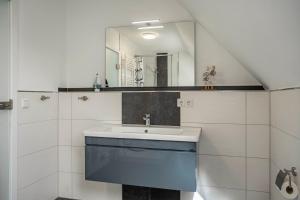 a bathroom with a sink and a mirror at 5 Sterne Ferienwohnung Boddenblick in Glowe +14 photos