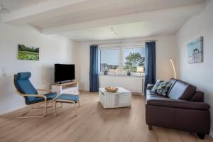a living room with a couch and a tv at 5 Sterne Ferienwohnung Boddenblick in Glowe