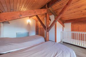 a bedroom with two beds and a wooden ceiling at Domaine de l'Arbizon in Bagnères-de-Bigorre
