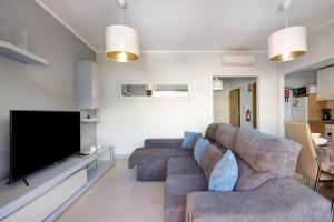 a living room with a couch and a flat screen tv at Royal Cabanas Golf 85 in Cabanas de Tavira