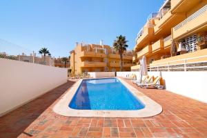 a swimming pool in front of a building at Royal Cabanas Golf 85 in Cabanas de Tavira