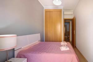 a bedroom with a pink bed with a pink blanket at Royal Cabanas Golf 85 in Cabanas de Tavira +15 photos