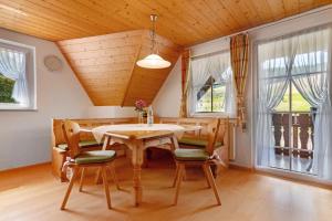a dining room with a table and chairs and windows at Danielenhof in Freiamt