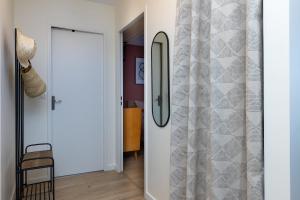a hallway with a sliding door with a shower curtain at Appart Anglet in Anglet +14 photos