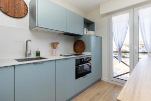 a kitchen with blue cabinets and a clock on the wall at Appart Anglet in Anglet