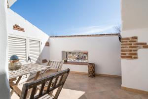 a patio with a table and a fireplace at Giojas125 Monolocale per 4 persone in Orosei