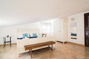 a room with a bed and a bench in it at Giojas125 Monolocale per 4 persone in Orosei