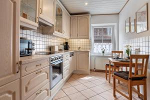 a kitchen with white cabinets and a table and a dining room at Ferien-Monteurwohnung Kaiser in Uelzen