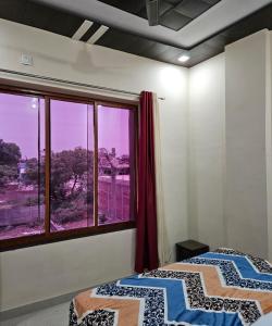 two beds in a room with a large window at The Hotel Siddhi Residency near Ram Mandir in Ayodhya