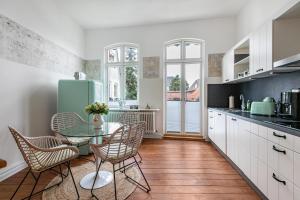 a kitchen with a table and chairs and a refrigerator at Wohnoase im Denkmal in Garding