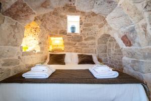 a room with a bed in a stone wall at Il Trullo di Mariangela in Ceglie Messapica