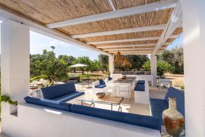 an outdoor patio with blue and white furniture and a wooden ceiling at Il Trullo di Mariangela in Ceglie Messapica