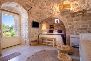 a bedroom with a bed in a stone wall at Il Trullo di Mariangela in Ceglie Messapica