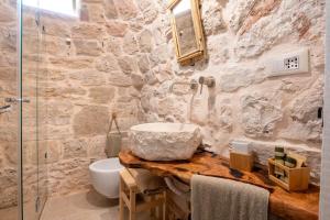 a stone bathroom with a sink and a shower at Il Trullo di Mariangela in Ceglie Messapica +23 photos