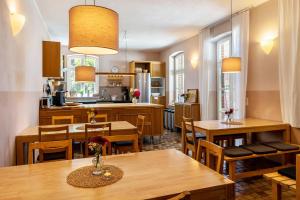 a kitchen and dining room with wooden tables and chairs at Der Flusshof, Ferienhaus in Werben
