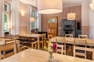 a dining room with tables and chairs and a fireplace at Der Flusshof, Ferienhaus in Werben
