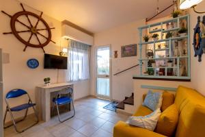 a living room with a yellow couch and a desk at Casa Erica in Stintino