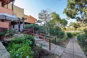 a garden with a walkway next to a building at Casa Erica in Stintino