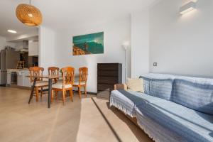 a living room with a couch and a table and chairs at Oceanfront Apartment With Pool in El Cotillo