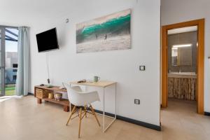 a white room with a desk and a computer in it at Oceanfront Apartment With Pool in El Cotillo