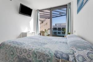 a bedroom with a bed and a large window at Oceanfront Apartment With Pool in El Cotillo +20 photos