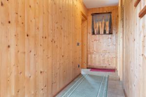a hallway with wood paneled walls and a rug at Paracia App La Vedla in Badia +24 photos