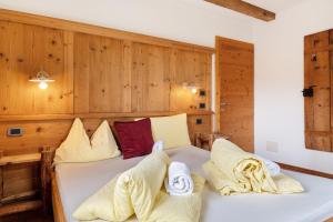a bedroom with a bed with two pillows on it at Paracia App La Vedla in Badia