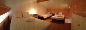 a small room with two beds and a lamp at La Tomate Surfeuse 1 in Hourtin +3 photos