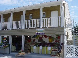 a store with a balcony on the side of a building at La Tomate Surfeuse 1 in Hourtin