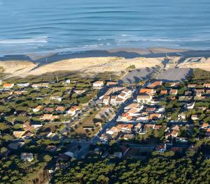 an aerial view of a small town next to the ocean at La Tomate Surfeuse 1 in Hourtin
