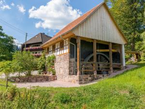 a barn with a large wheel in the front of it at Unterfalkenhof in Schramberg