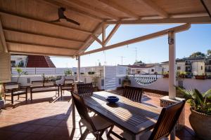 a patio with a wooden table and chairs on a roof at Casa Vacanza Giugiò in Giardini Naxos
