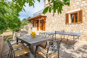a table and chairs in front of a stone building at Son Sant Joan in Alaró
