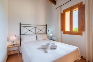 a bedroom with a white bed with a towel on it at Son Sant Joan in Alaró +18 photos