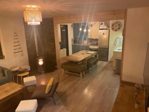 a living room with a table and chairs and a kitchen at Chez nous piste noire in Briançon