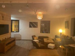 a living room with a couch and a tv at Chez nous piste noire in Briançon
