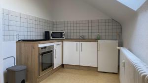 a small kitchen with a sink and a microwave at Wohnung an der Galopprennbahn in Iffezheim