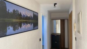 a hallway with a painting of a lake on the wall at Wohnung an der Galopprennbahn in Iffezheim