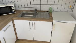 a kitchen with a sink and a microwave at Wohnung an der Galopprennbahn in Iffezheim +12 photos