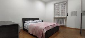 a bedroom with a bed and a desk and a window at Alloggio Tobia in Biella