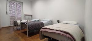 a bedroom with three beds and a window at Alloggio Tobia in Biella +13 photos