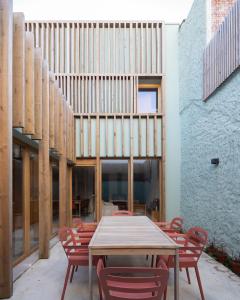 a table and chairs in a courtyard with a building at Fisherman's Blues - Beach House in Arcozelo +32 photos