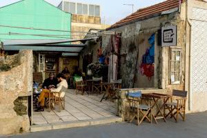 two people sitting at tables outside of a building at Fisherman's Blues - Beach House in Arcozelo