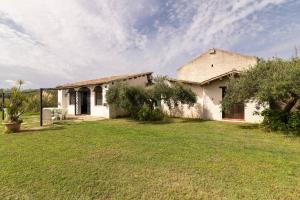 a white house with a yard with a grass field at Tenuta Donna Vittoria in Trapani